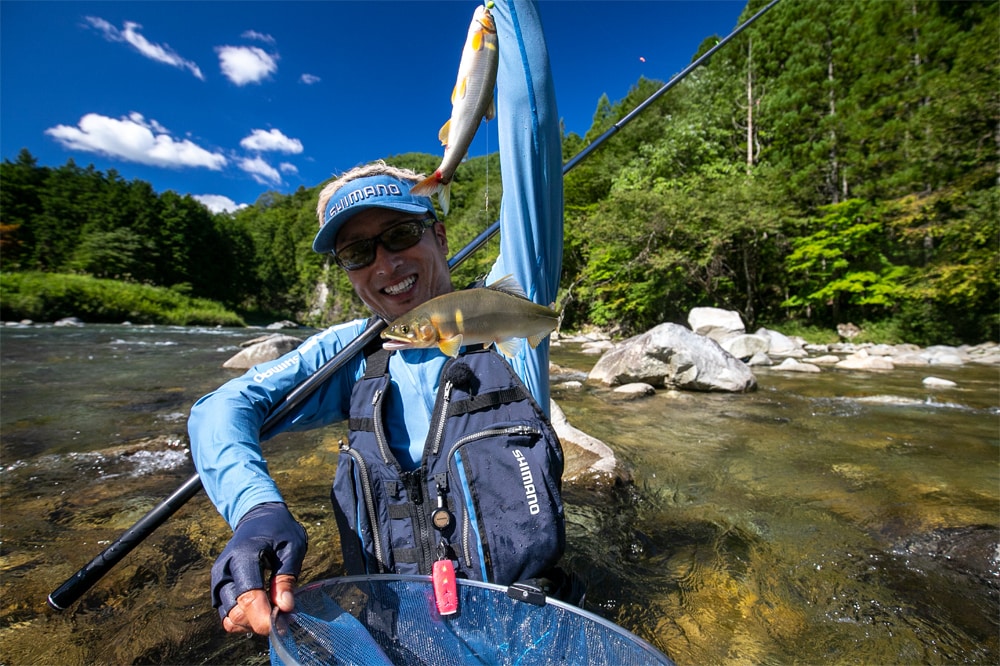 瀬の中で真っ黄色な馬瀬アユを釣りあげた湯川さん