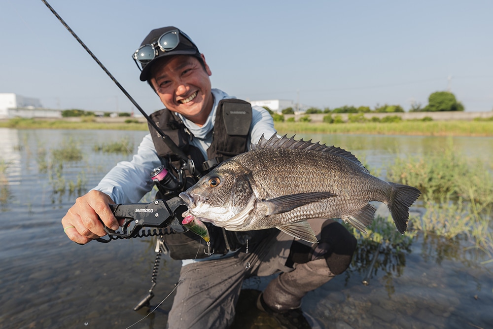 幸先の良い1匹に笑顔を見せる前田さん。ミスバイトの後ルアーのスピードを変化させて喰わせた。 幸先の良い1匹に笑顔を見せる前田さん。ミスバイトの後ルアーのスピードを変化させて喰わせた。