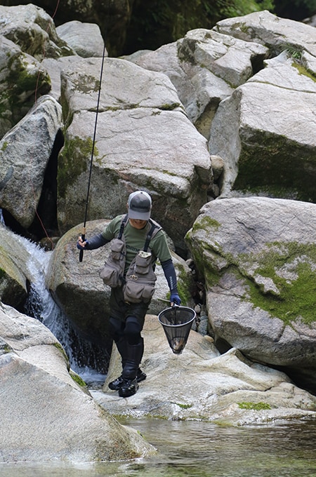 足場を移動して無事にランディング。玉網の奥で魚体が悶える。大きそうだ。