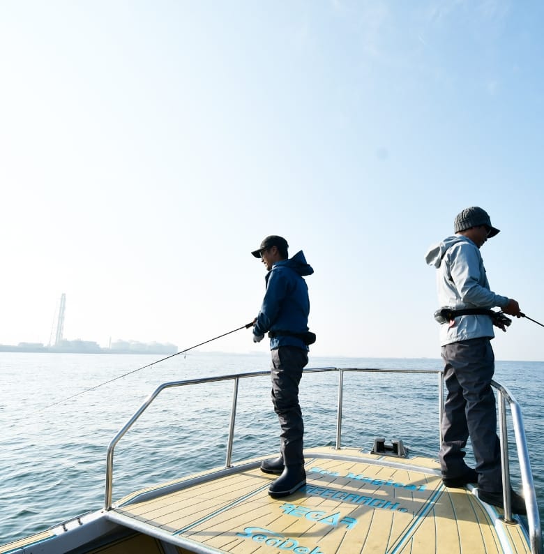 船上で釣り竿を下げる二人の男性